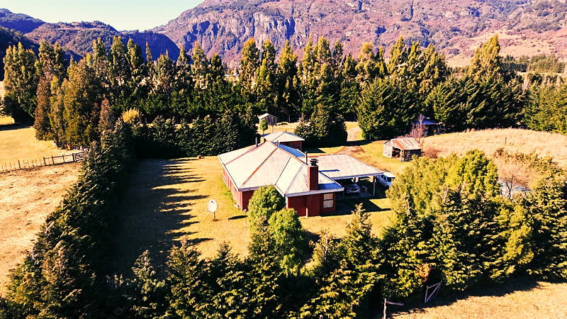Vista aérea de la casa principal del Fundo La Pampita con el cerro nevado de fondo, agosto 2026